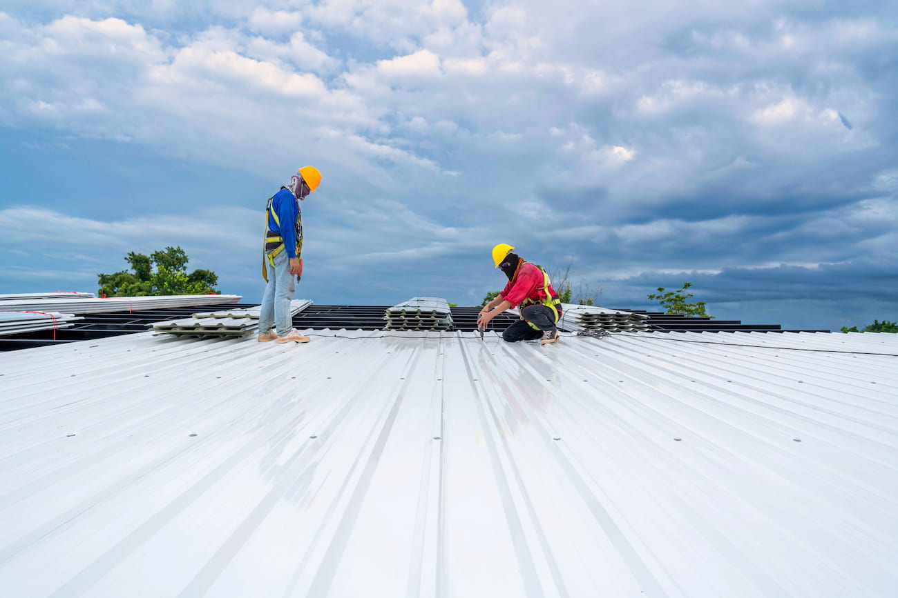 Roofers installing a roof on a new building