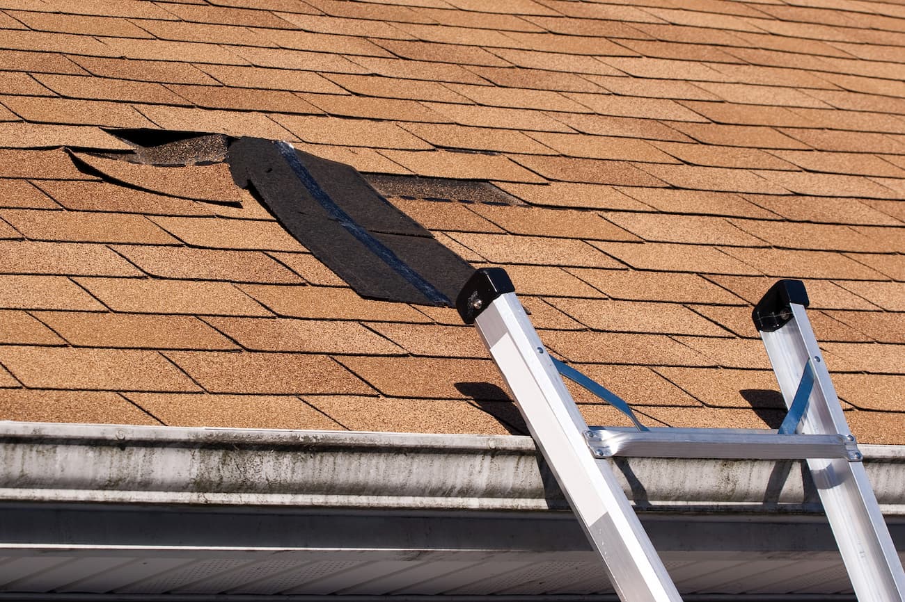 shingles being replaced on a damaged residential roof